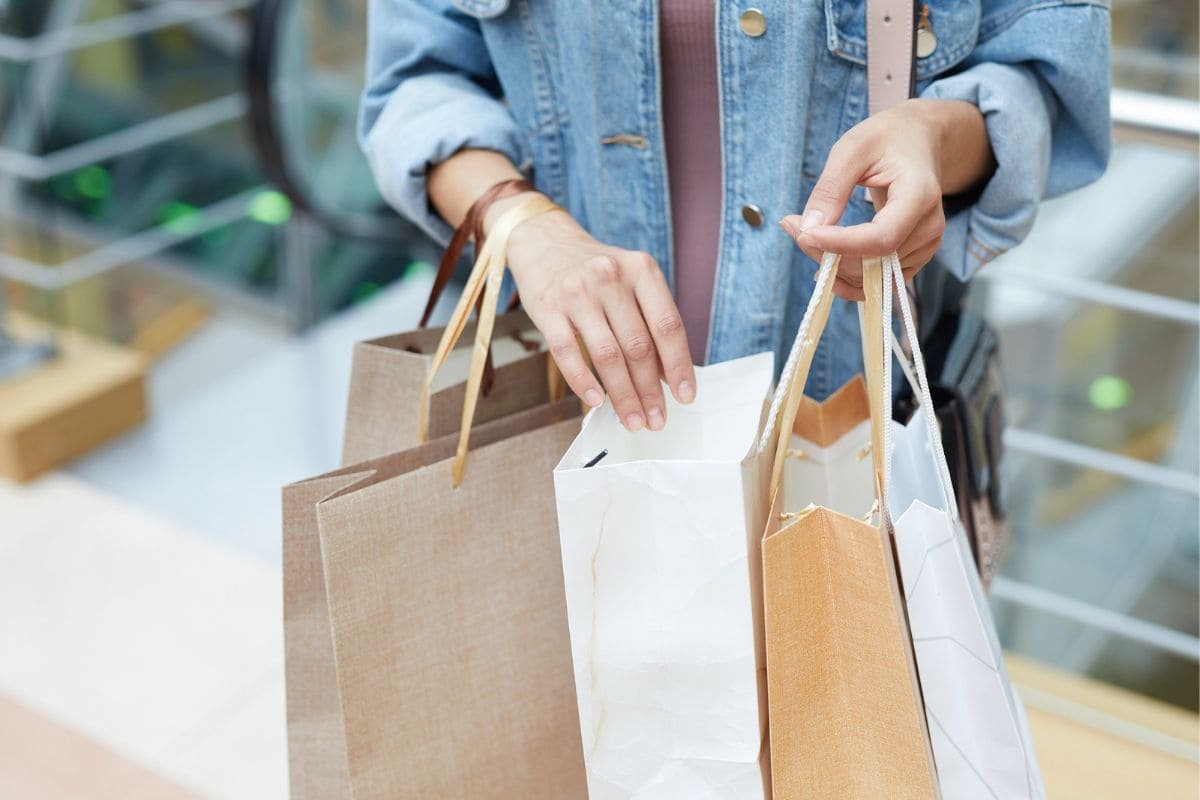 A mystery shopper looking through shopping bags.