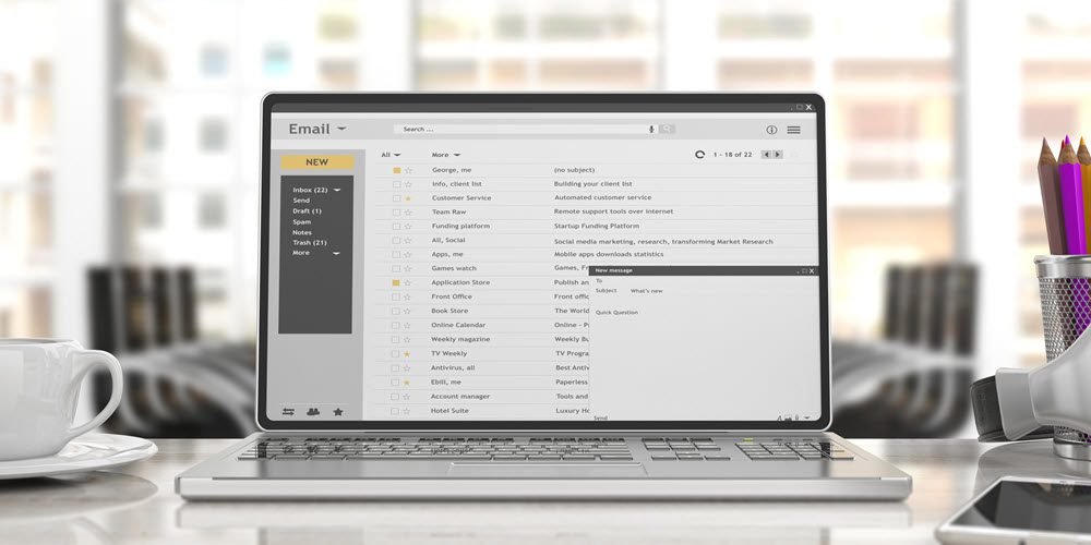 Image of a laptop screen showing a full email inbox with multiple subject lines and emails.